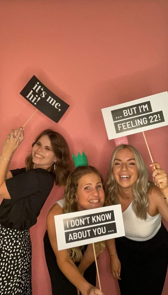 Beispielfoto: Gäste an der Tante Elfi Fotobox, lachen und nutzen bunte Requisiten